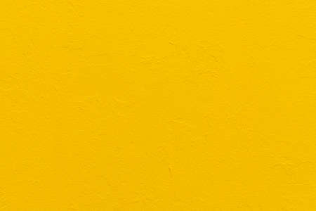 Abstract bright yellow painted wall textured backgroundの写真素材