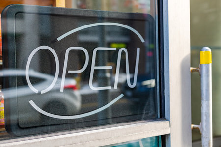 Close up of open sign on shop window in downtown of the city with reflection of the street in Ottawa, Canadaの写真素材