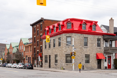 Ottawa, Canada - December 17, 2021: City view with traffic lights at crossroads and house with red roof in downtown. Woman crossing streetのeditorial素材