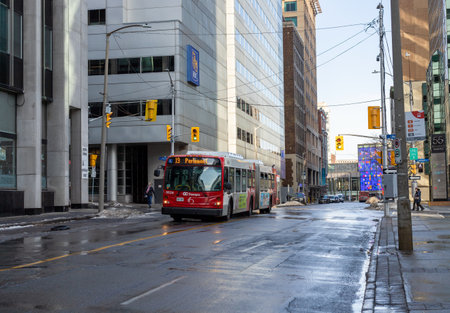 Ottawa, Canada - December 16, 2021: Public bus in downtown street of the city , going through intersection with traffic lights near bus stopのeditorial素材