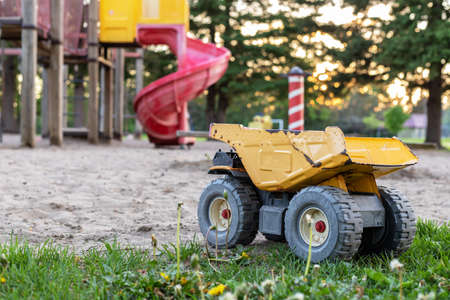 Old rusty toy truck abandoned in the park playground. Poor childhood concept.の写真素材