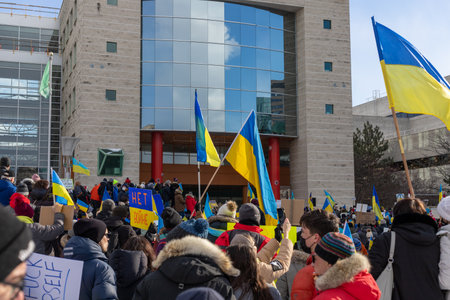 Ottawa, Canada - February 27, 2022: Rally in support of Ukraine against war. Protest near Ottawa City Hall against Russian invasion of Ukraine. People with Ukranian flagsのeditorial素材