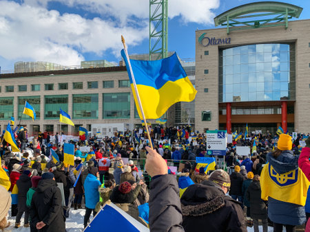 Ottawa, Canada - February 27, 2022: Rally with Ukrainian flags in support of Ukraine against war. Protest near Ottawa City Hall against Russian invasion of Ukraine.のeditorial素材