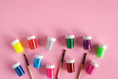 Paints and paintbrushes on pink background, flat lay with copy space. Art and crafts conceptの写真素材