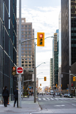 Ottawa, Canada - November 10, 2022: Traffic lights against sky and office buildings in downtown . Skyscrapers in business district of the city. Cityscape with skyscrapers and walking people.のeditorial素材