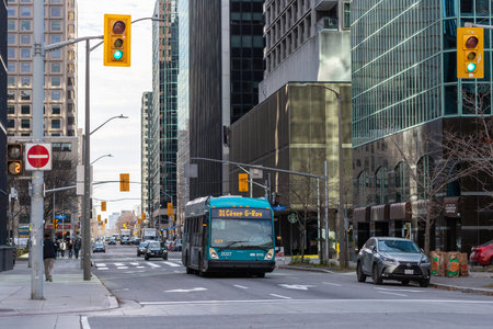 Ottawa, Canada - November 10, 2022: Public bus on road in downtown. Cityscape with busy traffic and...