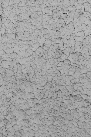 Peeling grey paint on the wall. Old cracked textured background.