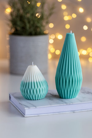 Handmade soy wax candles on a table with plant in a pot and lights in background. Cozy interiorの写真素材