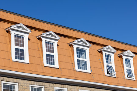 The top floor of a residential building. Row of windows of a house.の写真素材