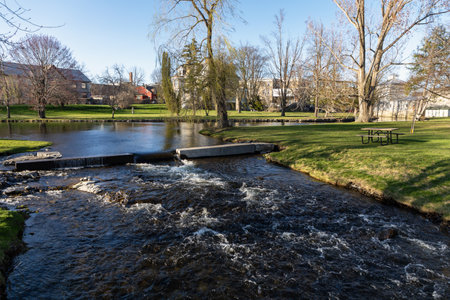 City park with a stream and picnic table in spring.の写真素材