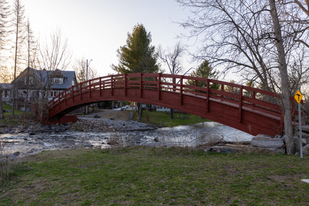 Red wooden bridge over a creek in Perth, Ontario, Canada in spring