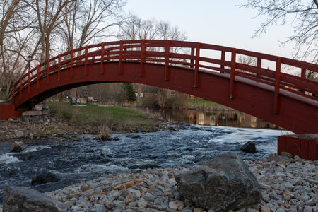 Red bridge over a stream in spring in the park. Perth town in Ontario, Canada.の写真素材