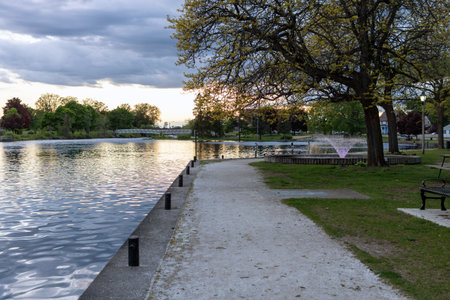 Park along river with fountain in Smiths Falls town in Ontario, Canada in spring season during sunset. Centennial Parkの写真素材