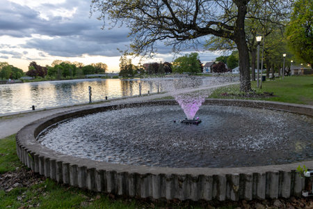 Park with lighted fountains along Rideau River in Smiths Falls town in Ontario, Canada in spring season during sunset. Centennial Parkの写真素材