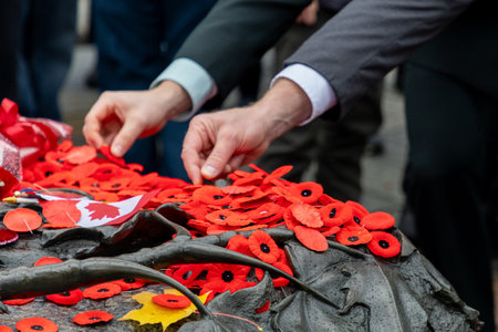 People placing red poppy flowers on the Tomb of the Unknown Soldier on Remembrance Day in Ottawa, Canada.の写真素材
