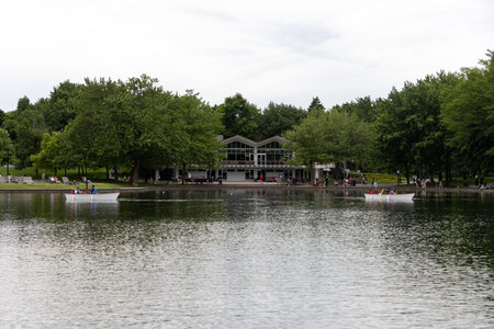 Montreal, Canada - July 5, 2025: Boating on Beaver Lake in summer. Modern pavilion at Lac aux Castors. Leisure activity on Montreal park lakeのeditorial素材