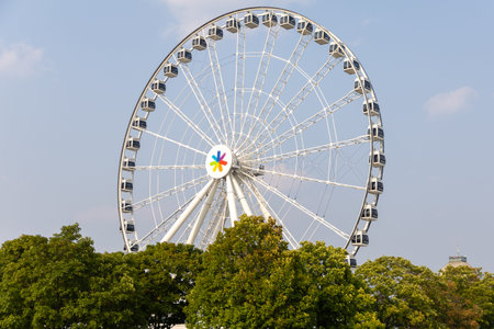 Montreal, Canada - August 2, 2025: Ferris Wheel over green lush trees in summer. Grande Roue de Montreal in Old Portのeditorial素材