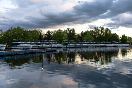 Smiths Falls, Canada - May 25, 2025: Rental cruiser boats at marina dock on Rideau Canal during sunsetのeditorial素材