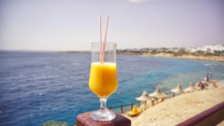 glass of fresh mango on the table on sea background