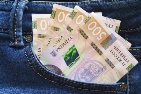 Ukrainian money. New banknotes five hundred hryvnia bills UAH in the back pocket of blue jeans. Money concept, Corruptionの写真素材