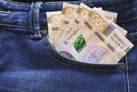 Ukrainian money. New banknotes five hundred hryvnia bills UAH in the back pocket of blue jeans. Money concept, Corruptionの写真素材