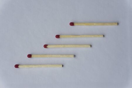 wooden matches lie in a row close up on a white background top view.の写真素材