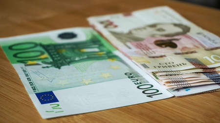 Ukrainian banknote hryvnias stacked against 100 euro banknote, reduction of the hryvnias and the euro close up. currency. Corruptionの写真素材