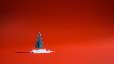 Top view snowy christmas tree with snow on the ground on red background. Minimal New Year concept. Flat layの写真素材