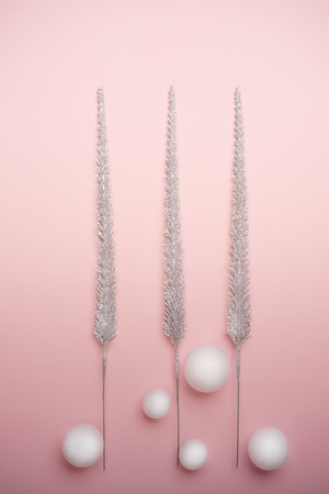 Christmas decorations shiny christmas trees and white balls on pastel pink background. New Year holiday winter concept. Flat lay top view copy space. Verticalの写真素材