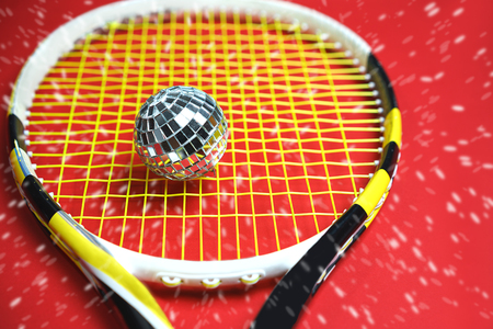 Christmas New year concept with disco ball as tennis ball on a tennis racket. top view, flat lay, close up. fitness, sport, game and health objects as lifestyle concept.の写真素材