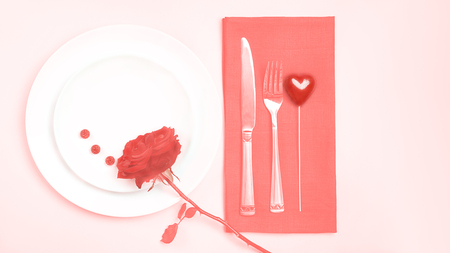 Panton color of the year 2019 - Living Coral. top view romantic table setting Valentines day dinner date celebration wedding with rose bud plates on tablecloth on coral pastel color background. tonedの写真素材