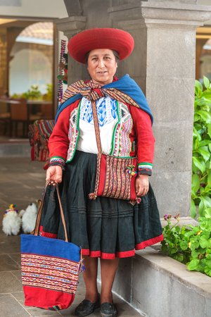 Cusco, Peru - 01.03.2019 Native Peruvian woman in traditional colorful dress with red hat in Sacred Valley near Cusco, Peru, Latin Americaのeditorial素材