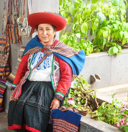 Cusco, Peru - 01.03.2019 Native Peruvian woman in traditional colorful dress with red hat in Sacred Valley near Cusco, Peru, Latin Americaのeditorial素材
