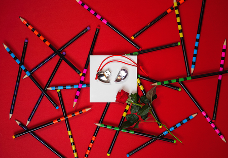 Flat lay layout white notebook Paris and red rose on red  with colorful office pencils.の写真素材