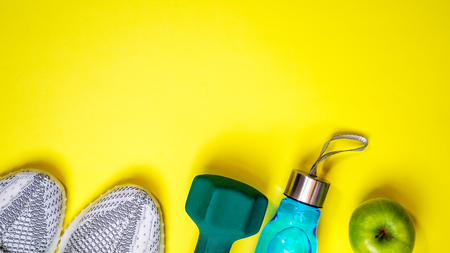Top view layout with fitness equipment and space for text on yellow colorの写真素材