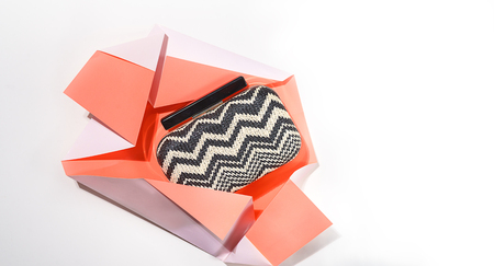 The concept of gift unwrapped from paper of living coral color on whiteの写真素材