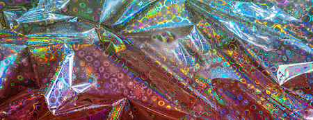 Holographic Abstract Foil Backdrop. Trendy creative hologram gradient rainbow. Flat lay, top view, selective focus.の写真素材