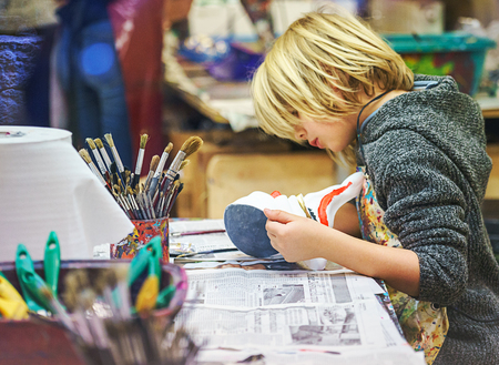 VENICE, ITALY - 02.23.2019: Happy face of little boy hands with venice tradition carnival mask, painting, making of mask during the carnival in Venice. Selective focusのeditorial素材