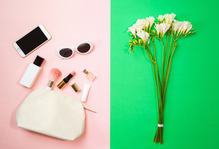 Flat lay female accessories cosmetics sunglasses mobile phone on pinkの写真素材