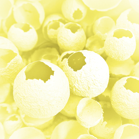 Cracked eggs pattern as gray and yellow background. Top view, flat lay, selective focus. Easter creative minimal concept. Eggshell texture for art background.の写真素材