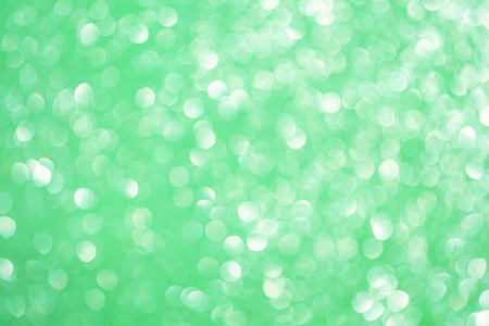 Blurred bokeh light green background, Christmas and New Year holidays background. Party concept. Festive holiday card bright backdrop. Defocused. Flat lay, top view, copy space.の写真素材
