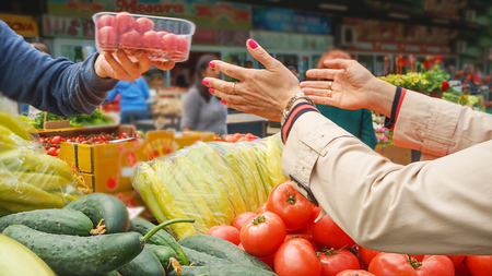 Woman buying fresh and organic fruits and vegetables at the green market or farmer agricultural marketの写真素材