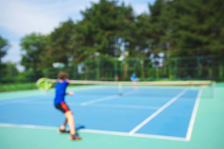 Teenager boy playing tennis on court.の写真素材