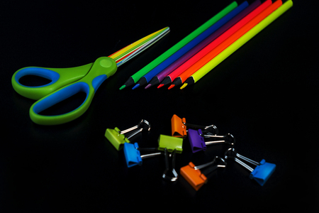 Back to school  with pencils, scissors, colorful paper clips on black backdrop.の写真素材