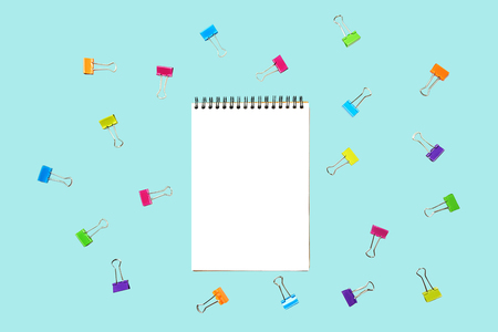 Back to school  with notepad, colorful paper clips on pastel blue backdrop.の写真素材