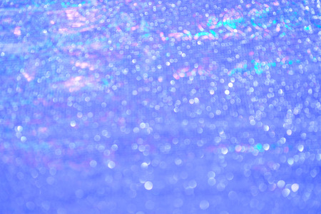 Blurred bokeh light blue pink holographic background, Christmas and New Year holidays background. Party concept. Festive holiday bright backdrop. Defocused.の写真素材