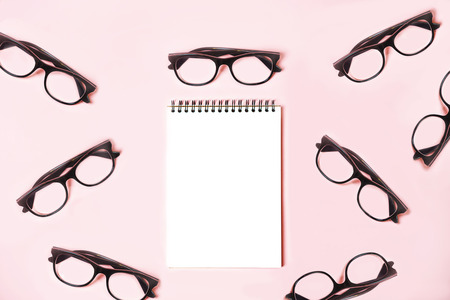 Notepad with trendy glasses on pastel pinkの写真素材