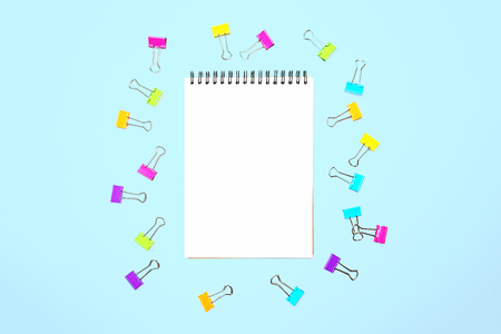 Back to school  with notepad, colorful paper clips on pastel blue backdrop.の写真素材