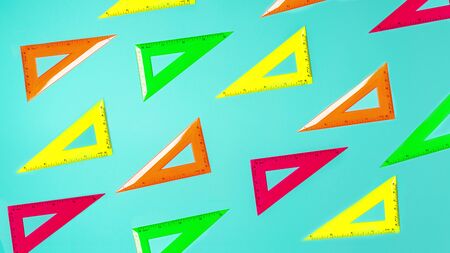 Creative layout of school supplies neon colors square rulers pattern against pastel blue background. Minimal back to school concept. Flat lay. Bright pink, yellow, orange, green color.の写真素材
