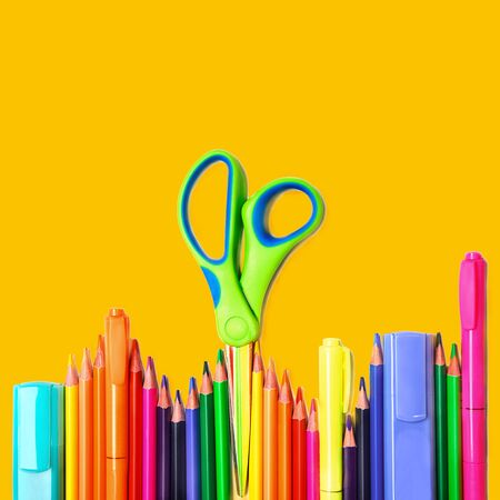 Back to school background with colorful pencils, scissors, markers on yellow backdrop, isolated. Flat lay, top view, copy space.の写真素材